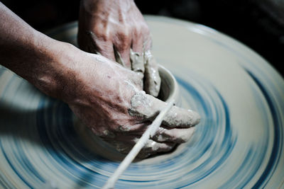 Cropped hands of man molding pot in workshop