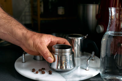 Man prepare classic italian coffee in the moka pot in the kitchen. coffee brake. morning habit.