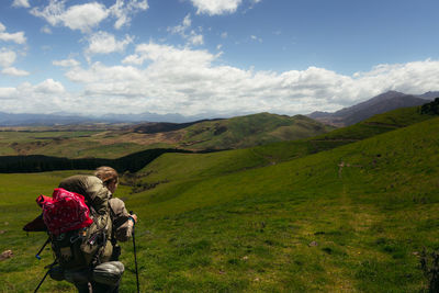 Rear view of women walking on mountain against sky