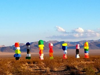 People on multi colored umbrellas against blue sky