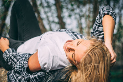 Smiling woman lying in forest