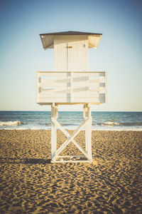 Lifeguard hut on beach against sky
