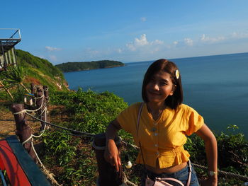 Woman smiling by sea against sky