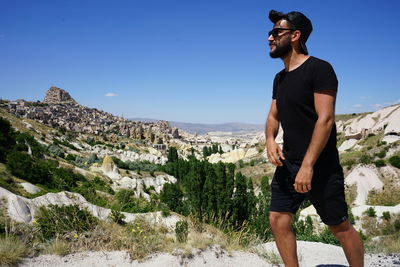 Full length of man standing on rock against sky