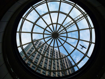 Low angle view of ceiling against tall building