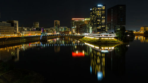 Illuminated buildings at night reflecting in the water of media harbour
