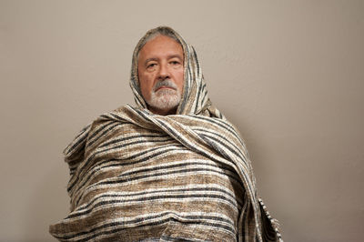 Portrait of smiling man standing against wall