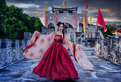 Portrait of woman standing against built structure