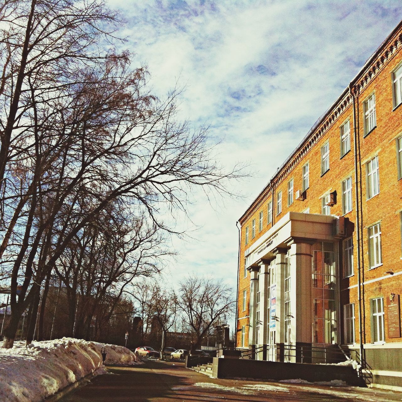 architecture, building exterior, built structure, sky, the way forward, tree, bare tree, house, residential structure, street, residential building, road, diminishing perspective, cloud - sky, day, outdoors, cloud, building, city, no people