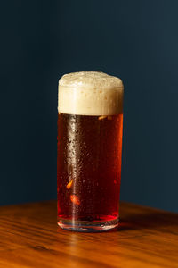 Close-up of beer glass on table against black background