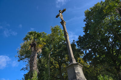 Low angle view of palm tree against blue sky