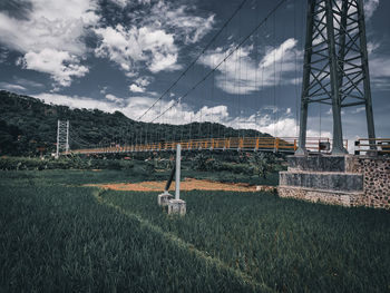 Electricity pylon on field against sky