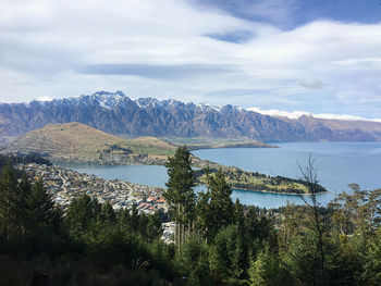 Scenic view of lake by mountains against sky