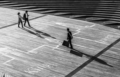 High angle view of people walking on walkway on sunny day