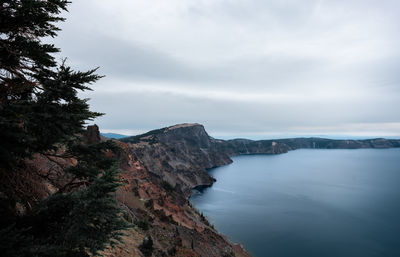 Scenic view of sea and mountains against sky