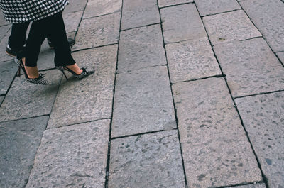 Low section of woman standing on footpath