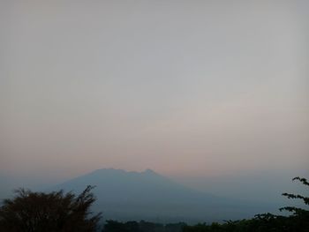 Scenic view of silhouette mountains against clear sky during sunset