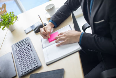 Midsection of businessman working on table