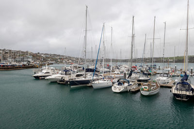 Sailboats moored in harbor