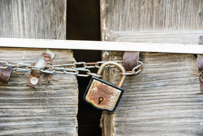 Close-up of rusty chain on wooden door