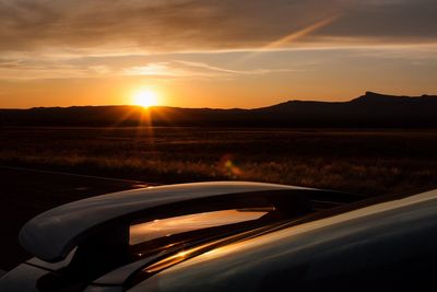 Car on road against sky during sunset