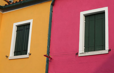 Low angle view of pink window on building