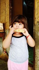 Portrait of cute girl holding ice cream standing outdoors