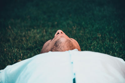 High angle view of man relaxing on grass at park