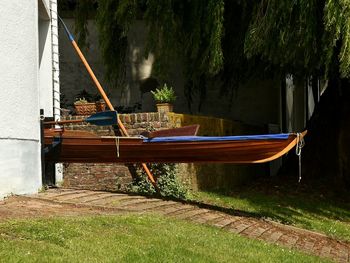 Boats moored on grass by trees