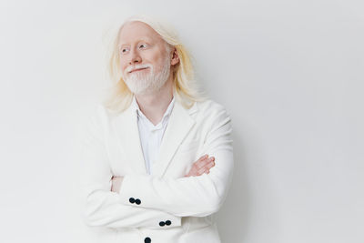 Portrait of beautiful young woman standing against white background