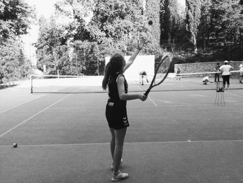 Full length of young woman playing guitar