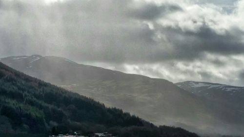 Scenic view of mountains against cloudy sky