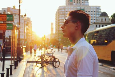 Side view of young man looking away in city