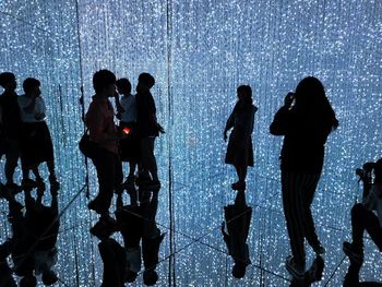 Silhouette people standing in rain at night