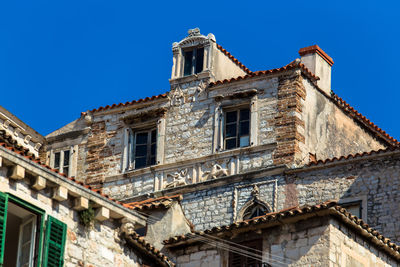 Low angle view of old building against clear blue sky