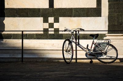 Bicycle parked by building in city