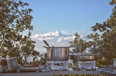 Cooking utensils on stove at table against sky