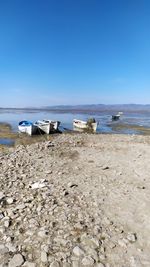 Scenic view of beach against clear blue sky