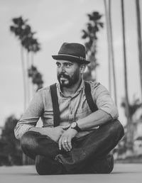 Full length of man sitting on road against sky