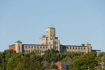 Low angle view of buildings against clear blue sky