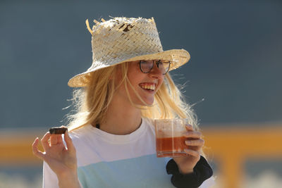 Portrait of a young woman drinking glass