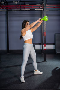 Full length of woman standing against wall