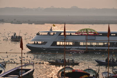 Boats moored on beach against sky during sunset