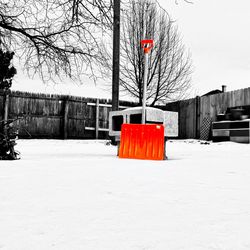 Red umbrella against snow covered trees