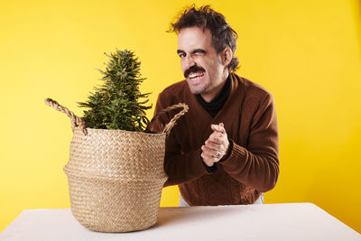 Side view of young man holding potted plant