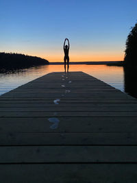 Silhouett of a girl, pier and sunset. traveling alone concept.