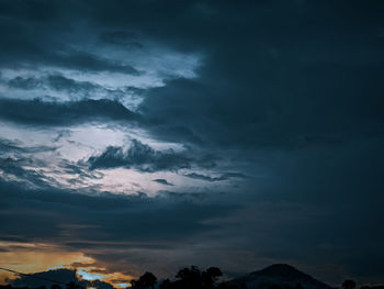 Low angle view of storm clouds at sunset