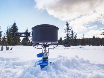 Cook at an winter outdoor campsite. cooking in winter with  black couldron above burning gas cooker