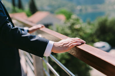 Midsection of businessman standing by railing