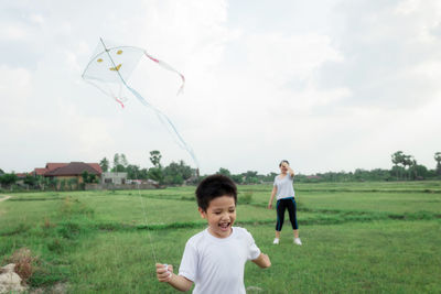 Children on field against sky